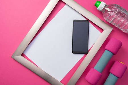 metal frame with a white background, a cell phone and a bottle of water, dumbbells lie on a general...