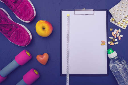 sports equipment - sneakers, dumbbells, an apple and a bottle of water, a mobile phone with...