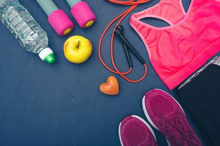 sports equipment - dumbbells, an apple and a bottle of water, yellow sneakers and clothesの写真素材