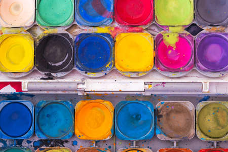 uncovered old palette of bright colored paints, close-upの写真素材