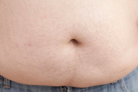 Fat man with a big belly, close-up part of the bodyの写真素材