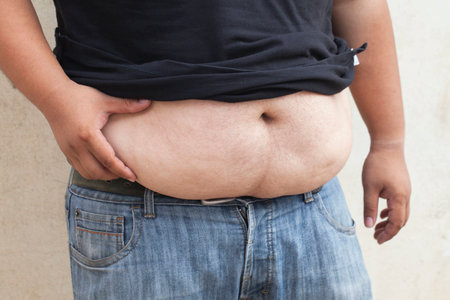 Fat man with a big belly, close-up part of the body