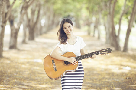 Young attractive woman playing acoustic guitar の写真素材