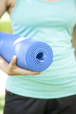 Young woman holding a yoga matの写真素材