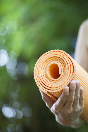 Young woman holding a yoga matの写真素材