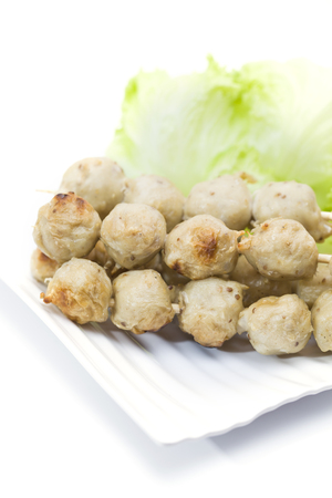 Pork ball in line by bamboo skewers with sauceの写真素材