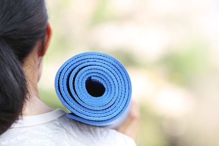 Young woman holding a yoga matの写真素材