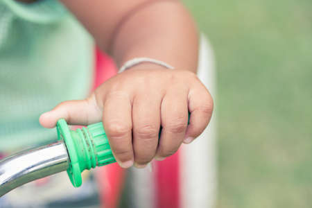 baby hand holding bicycle, vintage styleの写真素材
