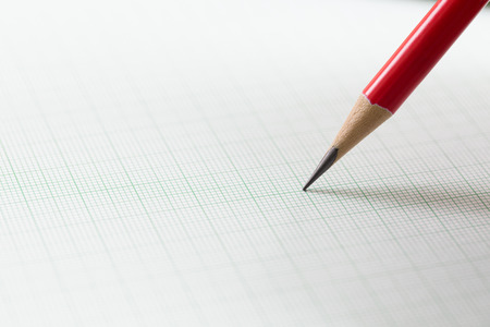 graph paper with red pencilの写真素材