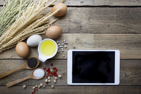 Food ingredients , kitchen utensils and tablet for cooking on wooden backgroundの写真素材