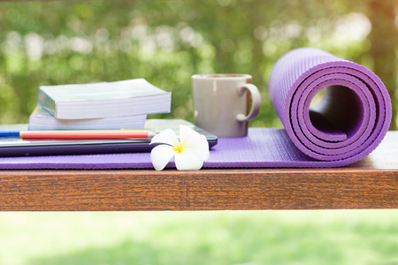 yoga mat and a cup of coffee on wood tableの写真素材