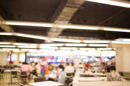 blurry defocused image of people eating food in food court for backgroundの写真素材