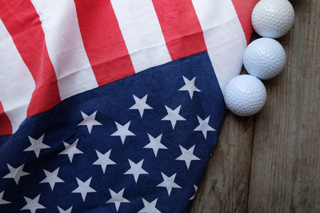 Golf ball with flag of USA on wood tableの写真素材