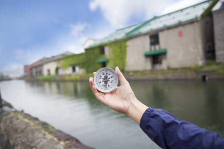 woman using a compass for travelers in Otaru Japanの写真素材