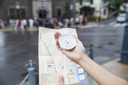 woman using a compass and map for travelers in Otaru Japanの写真素材