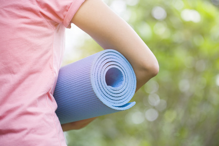 Young woman holding a yoga matの写真素材
