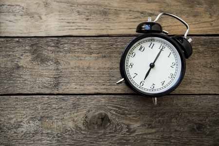 Retro alarm clock on wooden table