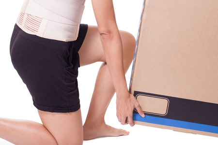 Woman carry a box with back support for muscle back,isolated on whiteの写真素材