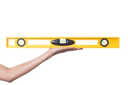 Yellow building level in woman hands. Isolated on a white background