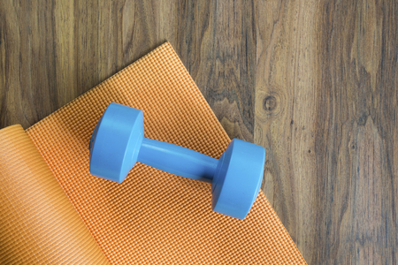dumbbell and yoga mat on wood tableの写真素材