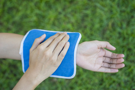 woman putting an ice pack on her arm painの写真素材