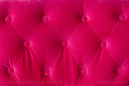 Red velvet couch background texture with sunken buttonsの写真素材