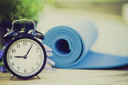 Time for exercising clock and yoga mat, outdoorの写真素材