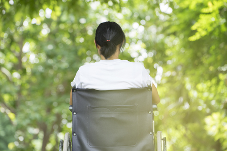woman using a wheelchair in a parkの写真素材