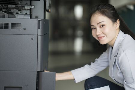 asian woman secretary using copy machine in the office