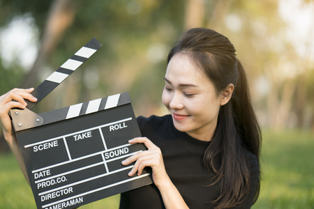 asian girl holding clapper board in her handsの写真素材