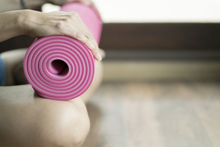 Young woman holding a yoga matの写真素材