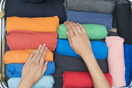 Travel planning and a traveler packing a luggage for a new journeyの写真素材