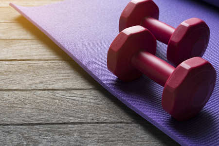 dumbbell and yoga mat on wood tableの写真素材