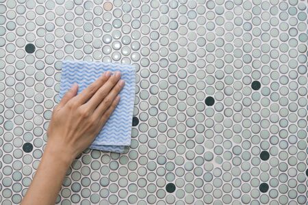 Cleaning tile wall by woman handの写真素材