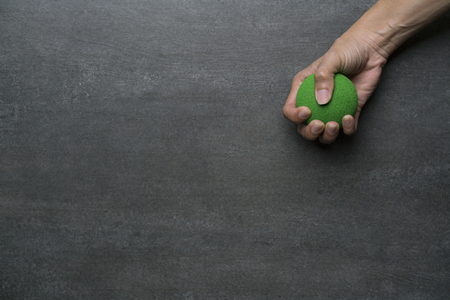 woman hand holding stress ball on black backgroundの写真素材