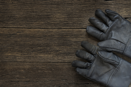 old dirty leather work gloves on wood backgroundの写真素材