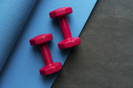 dumbbell and yoga mat on table, fitness healthy and sport concept