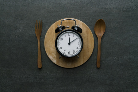 Food clock at lunch time. Healthy food concept on wooden tableの写真素材