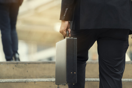 Businessman climbing up a concrete staircase concept on successの写真素材