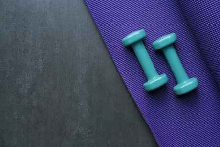 dumbbell and yoga mat on table, fitness healthy and sport conceptの写真素材