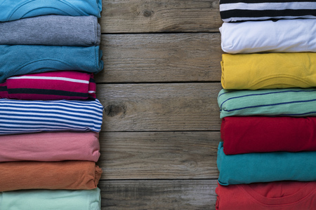 close up of rolled colorful clothes on wood table background