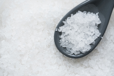 Crystal sea salt for food ingredient in a spoon, close up