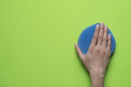 Cleaning table with green background by woman hand