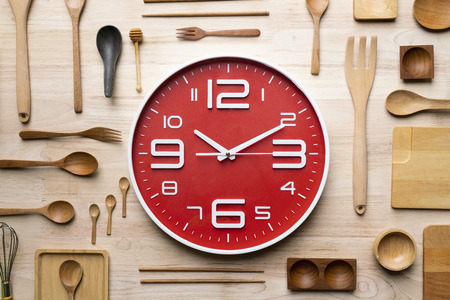 clock and kitchen utensils for cooking. Healthy food concept and prepare food on wooden table backgroundの写真素材