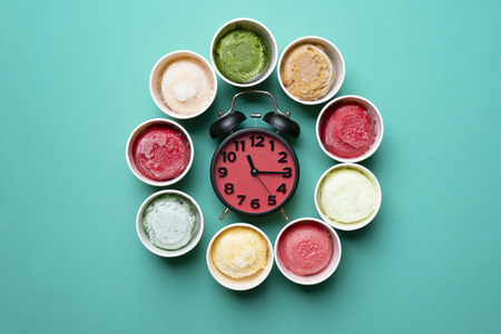 ice cream with a alarm clock on green background