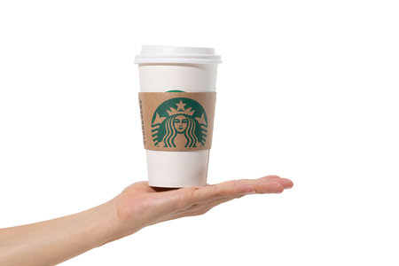Bangkok, Thailand - July 8, 2018: Female hands holding a cup of Starbuck coffee on white backgroundのeditorial素材