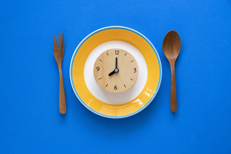 Food clock. Healthy food concept on blue backgroundの写真素材