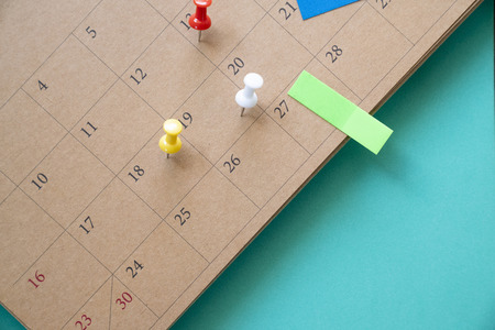 close up of calendar and pin on the green table, planning for business meeting or travel planning...