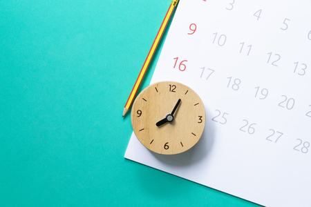 close up of calendar and clock on the green background, planning for business meeting or travel planning conceptの写真素材