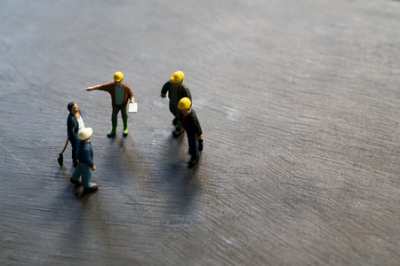 Miniature model engineers were consulted together and planning on the black table backgroundの写真素材